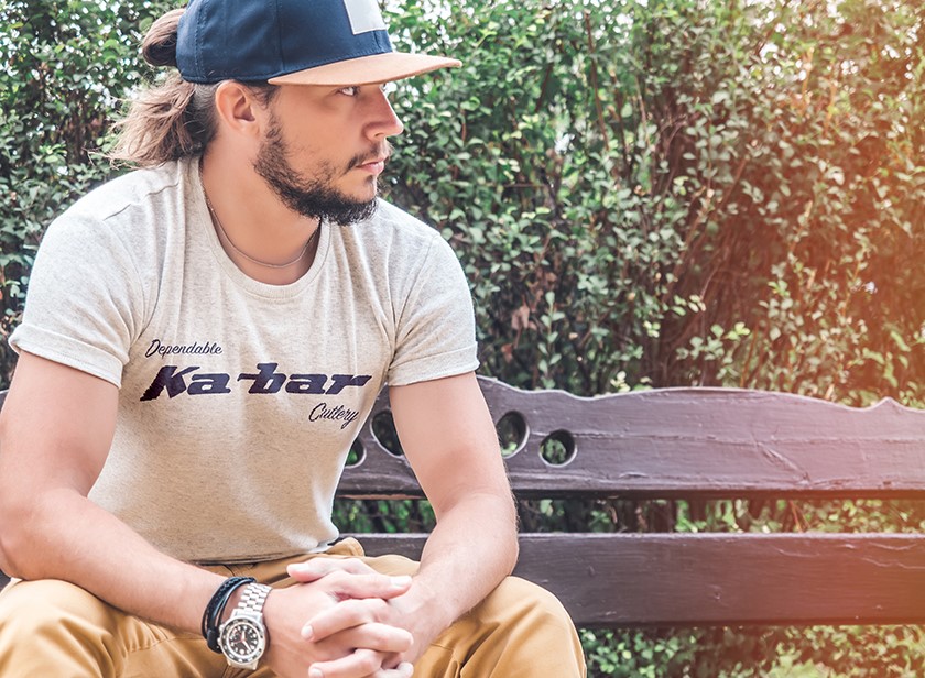 Man wearing a Kabar shirt sitting on a bench
